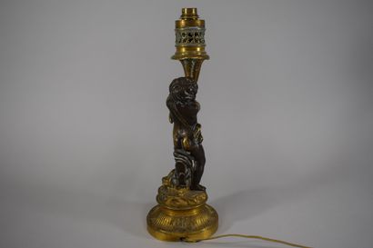 null Bronze lamp representing a putto, a cymbal at its feet, round fluted base decorated...