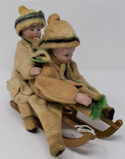 Two children on a sledge, heads and hands...