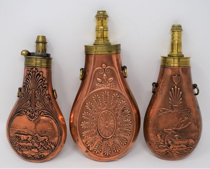 null Three brass and copper embossed powder flasks with cygetic decoration, with...