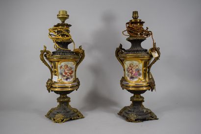 null A pair of polychrome porcelain oil lamps decorated with a bust of a woman on...