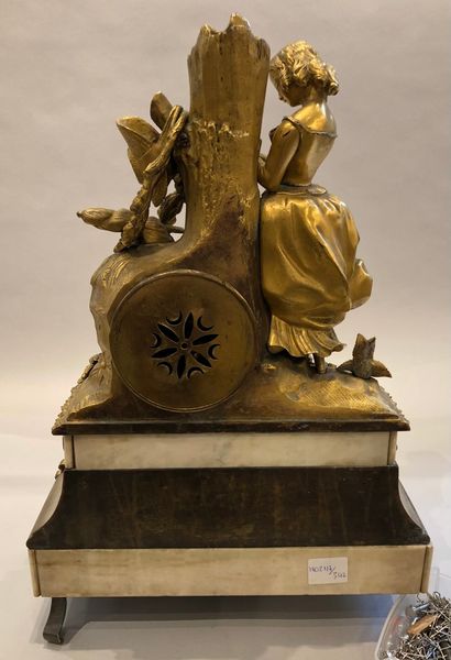 null Pendule en bronze doré reposant sur une base de marbre blanc figurant une jeune...