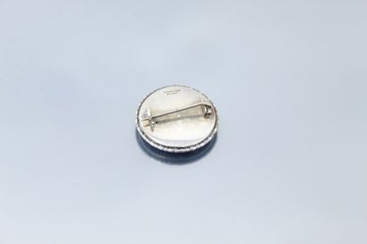 null Silver brooch, round shape, representing a woman playing an instrument in a...