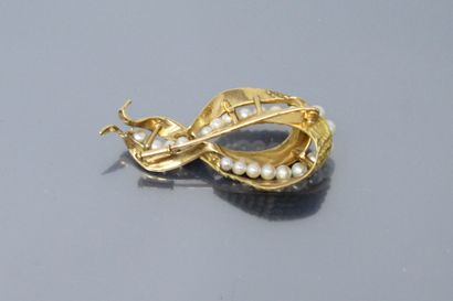  Broche « nœud » en or jaune 18K (750) texturé et amati, serti d'une ligne de perles...