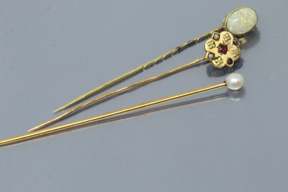 null Set of three 18K (750) yellow gold tie pins, one with a cabochon opal, another...