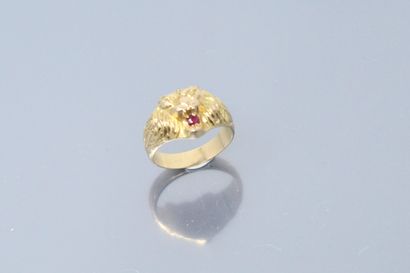 null 18k (750) yellow gold ring styling a lion's head holding a ruby in its mouth....