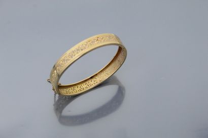 null Rigid opening bracelet in 18k (750) yellow gold, decorated with an openwork...