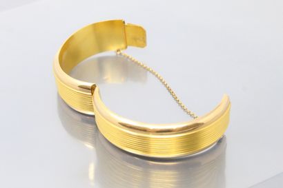 null Rigid 18K (750) yellow gold opening bracelet, smooth and grooved, safety chain.

Second...