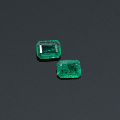 null A pair of rectangular emeralds with cut sides on paper. 

Accompanied by an...