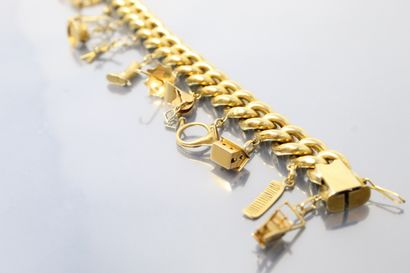 null 18K (750) gold bracelet with a French curb chain holding twelve charms of various...