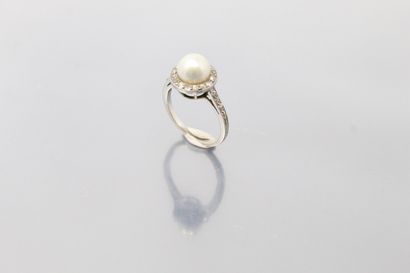 null An 18K (750) white gold ring centered on a fine button pearl surrounded and...