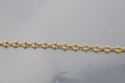 null Bracelet en or jaune 18K (750) à maille forçat aux anneaux rehaussées de bagues.

Poinçon...