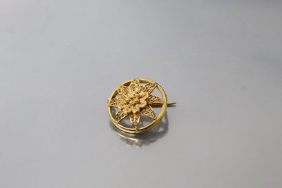 null Broche en or 18K (750) de forme circulaire et filigranée à motif de fleur. Dans...
