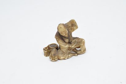 null JAPAN - 20th century

Carved ivory netsuke of a man sitting with a coloquint...