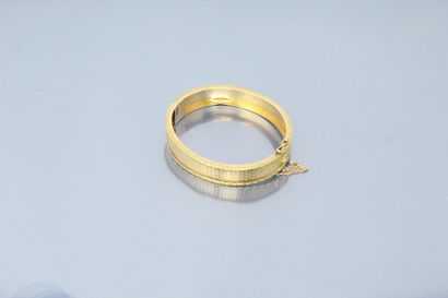 null Bracelet rigide en or jaune 18k (750) ouvragé d'un semi de fleurettes. 

Poinçon...