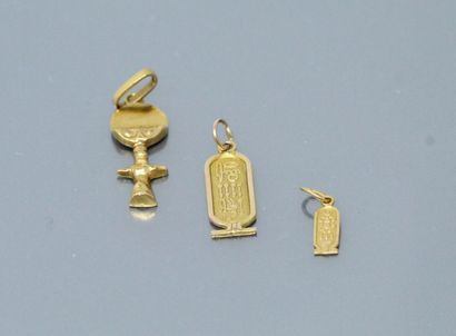 null Two 18k (750) yellow gold pendants, one with an Egyptian motif and one featuring...