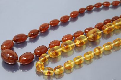 null Set of two amber and plastic necklaces. One with an 18k (750) yellow gold c...