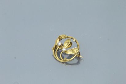 null Broche ronde ajourée en or jaune 18k (750) rehaussée d'une perle et d'un diamant,...