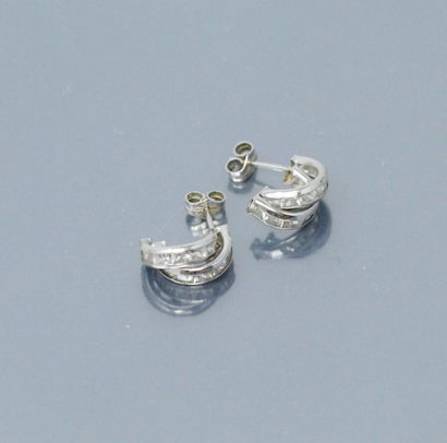 null Pair of 18k (750) white gold earrings, each set with calibrated white stones....