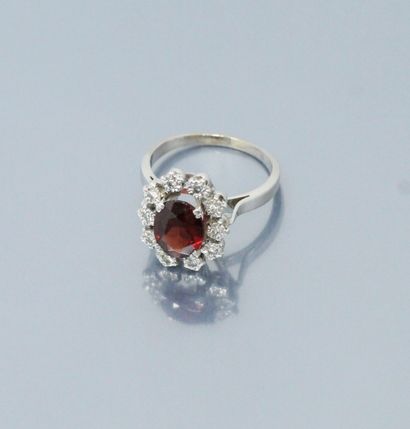 null 18k (750) white gold ring set with an oval garnet in a diamond setting. 

Hallmark...