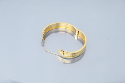 null Bracelet rigide en or jaune 18k (750) ouvragé d'un semi de fleurettes. 

Poinçon...
