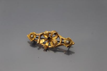 null Broche en or jaune 18k (750) formé d'un noeud et de fleurettes ornés d'un rubis...
