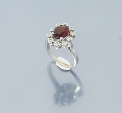 null 18k (750) white gold ring set with an oval garnet in a diamond setting. 

Hallmark...