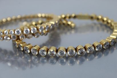 null Two 18k (750) yellow gold and steel bracelets with white crystals.

Signed DANIEL...