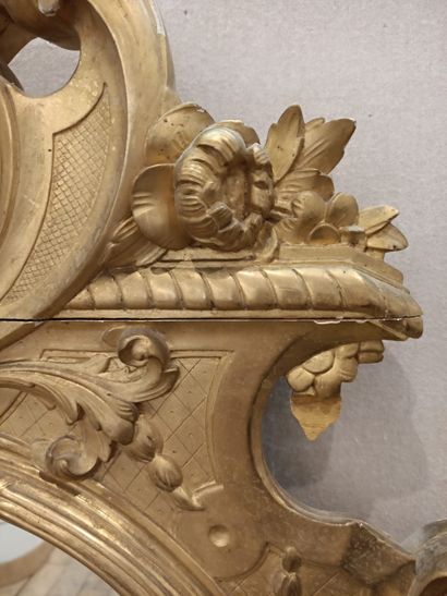 null A carved and gilded wood mirror with a mascaron and a cherub head.

Regency...