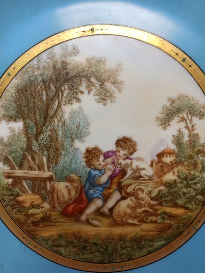 null A slightly hollow plate decorated with two children playing with a dog on a...