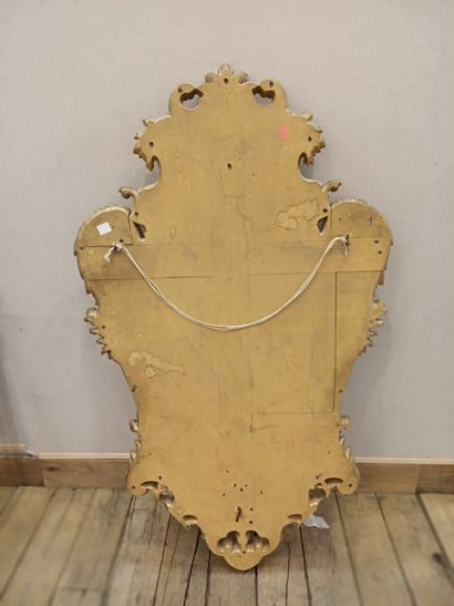 null A carved and gilded wood mirror with a mascaron and a cherub head.

Regency...