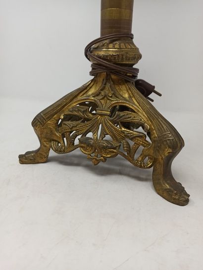 null Bronze candlestick with cylindrical shaft resting on a tripod base decorated...