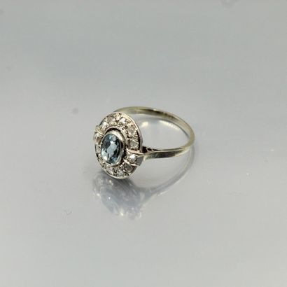 null An 18K (750) white gold and platinum oval ring set with an oval aquamarine in...