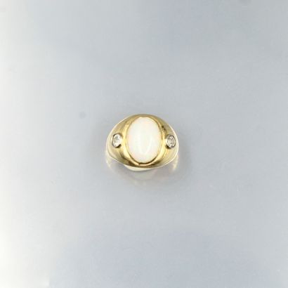 null Bague en or jaune 18K (750) sertie d'un cabochon d'opale épaulé de deux diamants...
