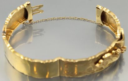 null Bracelet rigide ouvrant en or jaune 18K (750) à décor de rinceaux et feuillages...