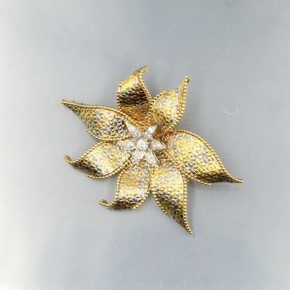 null An 18K (750) two-tone gold brooch styling a flower with hammered decoration;...