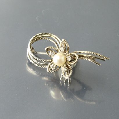 null 
Broche en or gris 18k (750) à motif de fleur avec une perle centrée et 5 diamants...