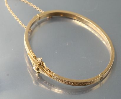 null 
Bracelet rigide en or jaune 14k (585) orné d'une perle, et de motifs floraux...