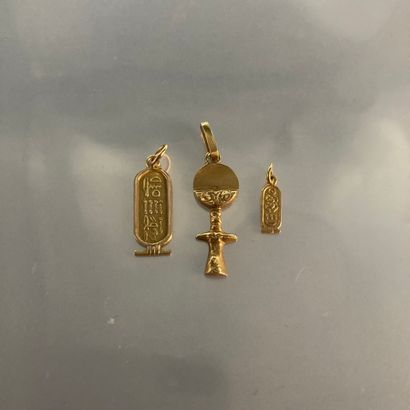 null Two 18k (750) yellow gold pendants, one with an Egyptian motif and one featuring...