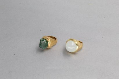 null Set of two 18k (750) gold rings.

One with a white cabochon stone and the other...