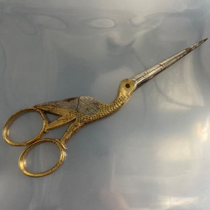 null A pair of steel scissors, partly gilded, representing a bird.

L. : 16.50 cm...