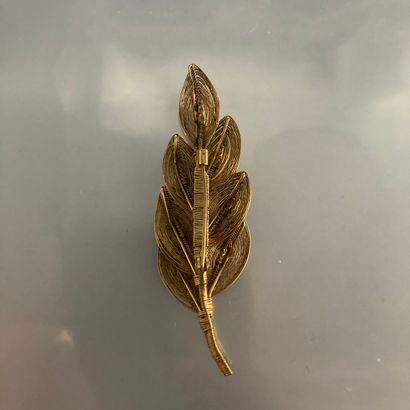 null Gilt metal filigree brooch styling a leafy branch. 

Length: 7.5 cm.