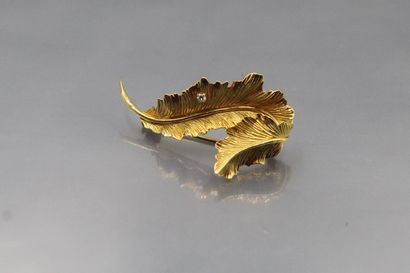 null 18k (750) yellow gold brooch styling a leaf set with a round diamond. 

Gross...