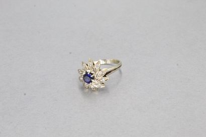 null 18K (750) white gold flower ring set with a blue imitation stone, the petals...
