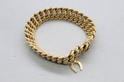 null Bracelet en or jaune 18k (750) à maille américaine et une breloque en forme...