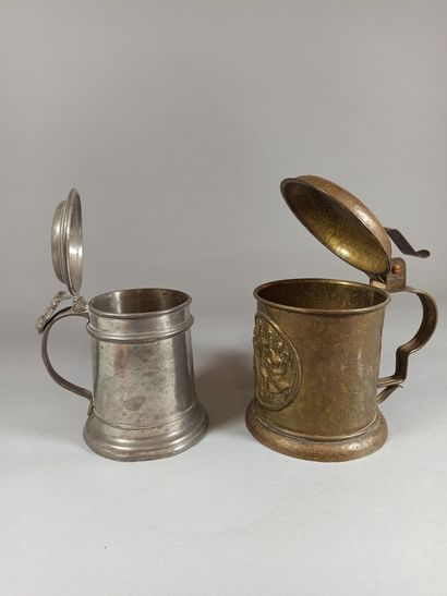 null Set of two beer mugs, 

One in pewter, the other in hammered brass decorated...