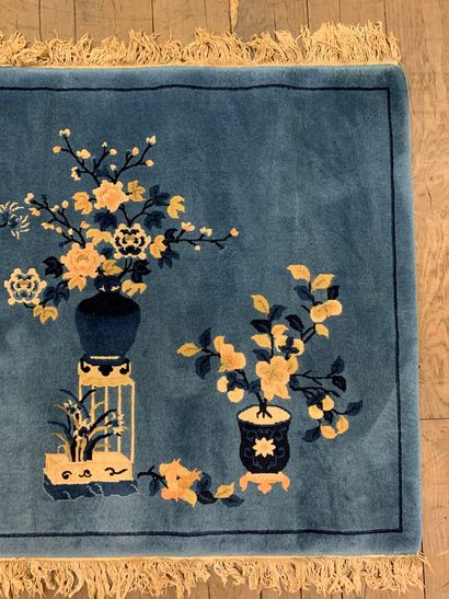 null 
Tapis en laine à décor de vases et paniers fleuris sur un fond bleu.
Franges
Chine...