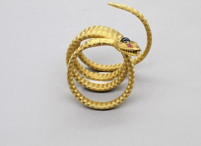 null 
Bracelet en or jaune 18K (750) figurant un serpent, la tête ornée d'un cabochon...