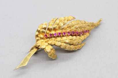 null Brooch in 18K (750) yellow gold with a leaf, in the center a line of red stones.

Pin...