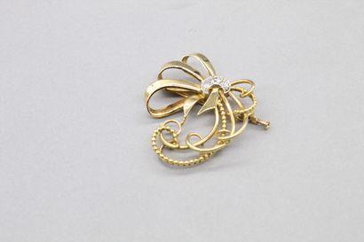 null 18K (750) yellow gold and platinum bow brooch, one of the links is beaded, in...