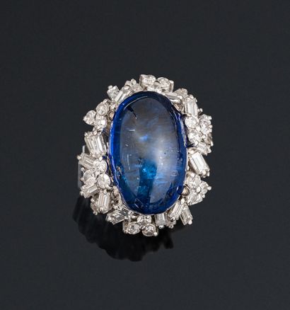 null Ring in 9K (375) white gold set with a cabochon sapphire surrounded by baguette-cut...